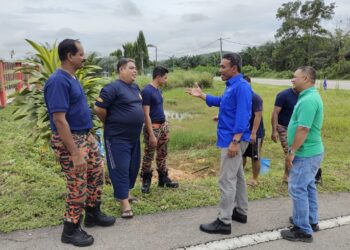 MOHD. Isam Mohd. Isa (depan, dua dari kanan) beramah mesra dengan anggota bomba yang bergotong-royong di Balai Bomba Gemencheh, Tampin pagi tadi.-UTUSAN/ NOR AINNA HAMZAH