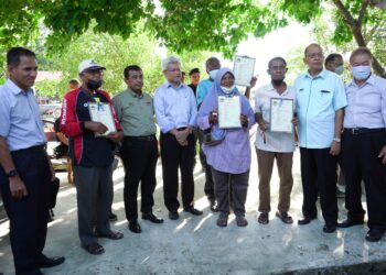 AHMAD ZAKIYUDDIN Abdul Rahman (empat dari kiri) bersama sebahagian nelayan yang menerima bantuan bot, enjin serta peralatan berkaitan di bawah skim SIMP di Butterworth, Pulau Pinang kelmarin.