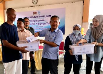 YUSOFF Othman (tiga dari kanan) menyampaikan bantuan wang dan kit makanan kepada nelayan terjejas dengan banjir di Kompleks LKIM Tumpat, Kelantan, hari ini.-UTUSAN/ ROSLIZA MOHAMED