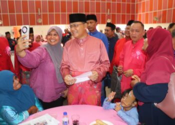 JOHARI Harun (tengah) melayani tetamu sempena majlis Rumah Terbuka Aidilfitri peringkat Dewan Undangan Negeri Pelangai di Felda Kemasul di Bentong, Pahang. - UTUSAN/SALEHUDIN MAT RASAD
