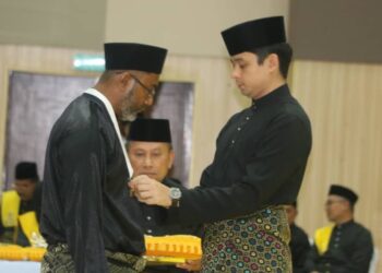 TENGKU HASSANAL IBRAHIM ALAM SHAH Ibni Al-Sultan Abdullah Ri’ayatuddin Al-Mustafa Billah Shah (kanan) memakaikan pingat SAP kepada seorang penerima di Temerloh, Pahang. - UTUSAN/ SALEHUDIN MAT RASAD